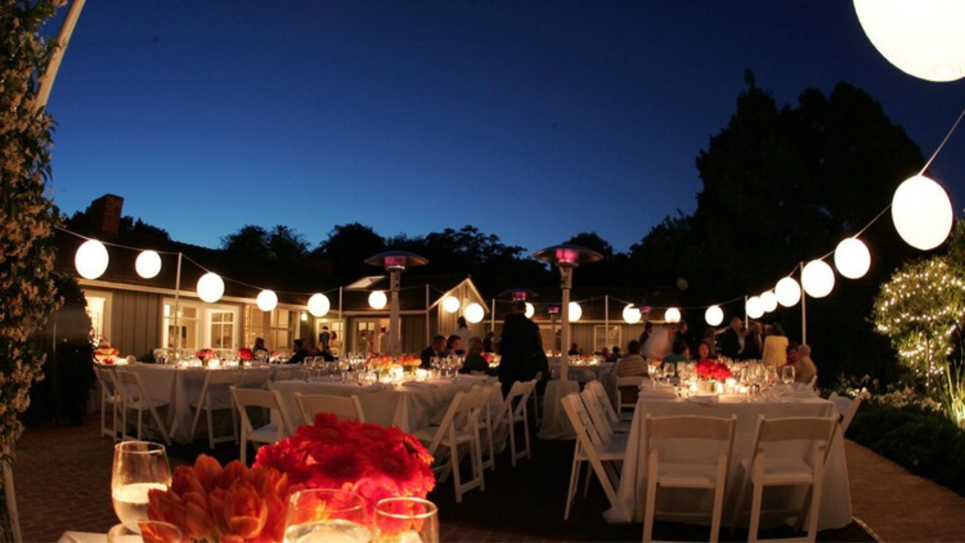 a party decoration with light, tables and chairs showing party planning 