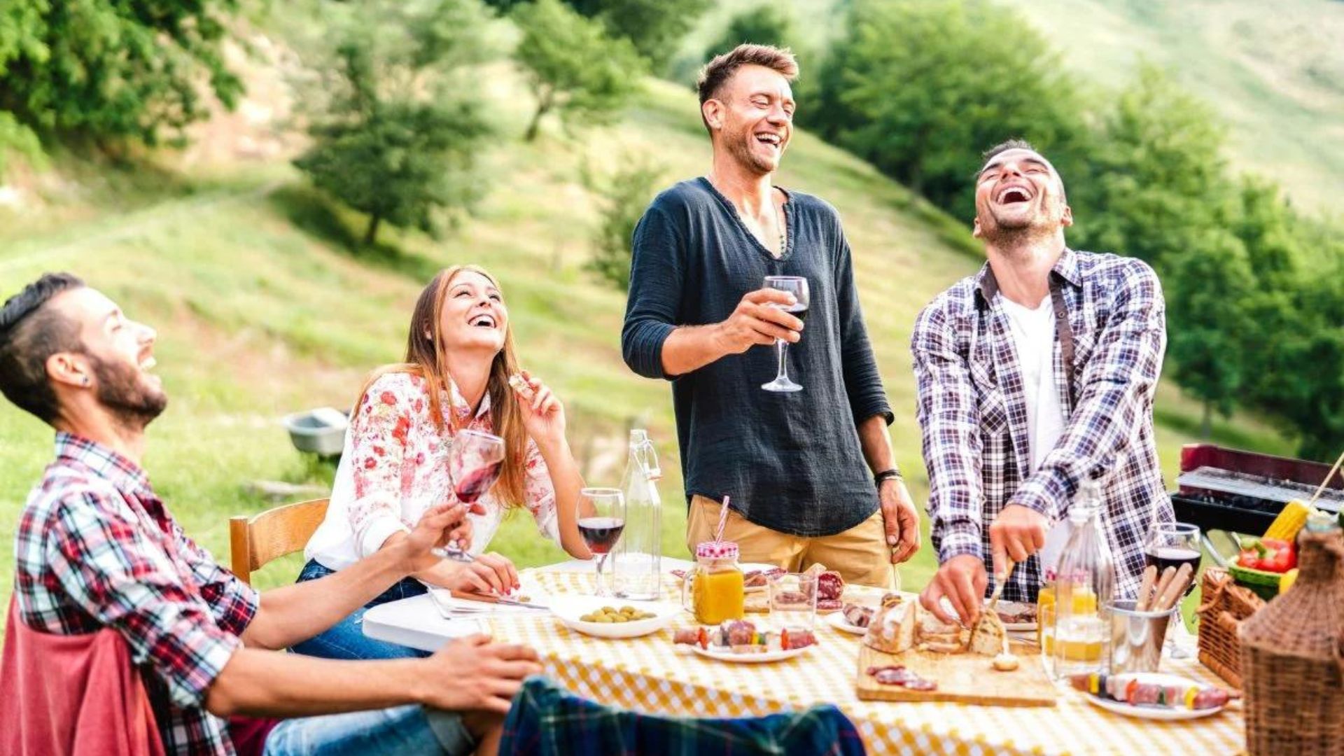 people laughing while having drinks showing an outdoor party 