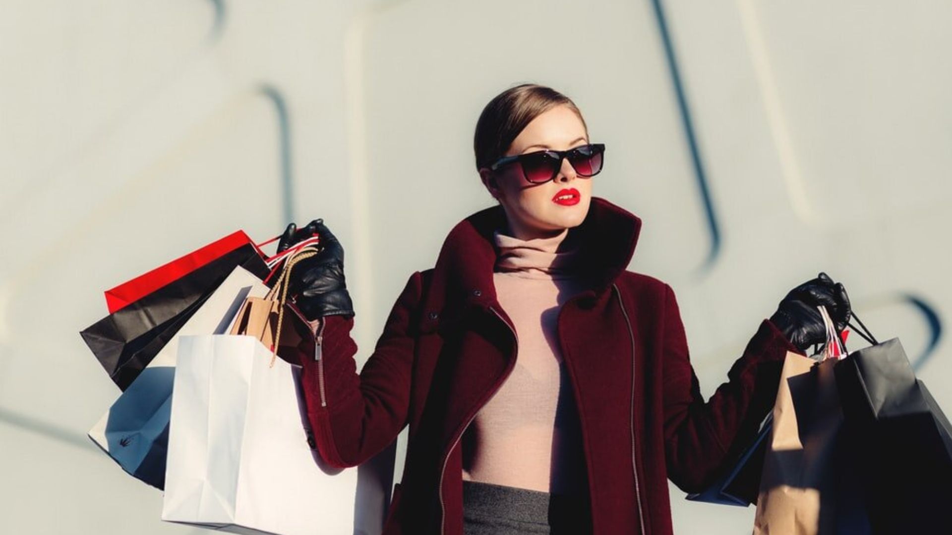 a lady wearing glasses holding shopping bags with fashion nova clothes